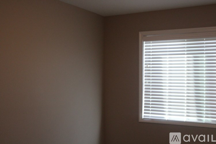 A window with white blinds in a room.