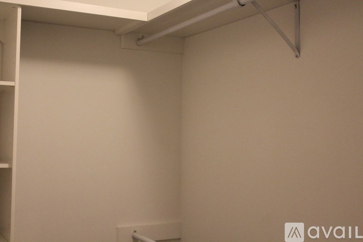 A white wall with a shelf and a white pipe.