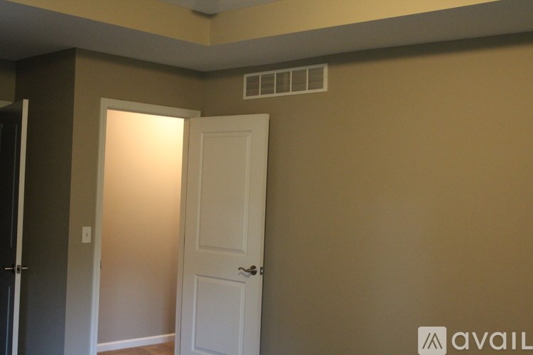 A room with a white door and a wall-mounted air conditioner.