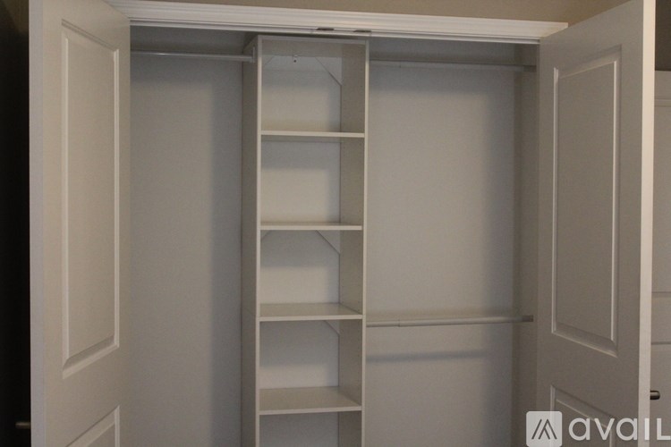 A white pantry with shelves and a door open.