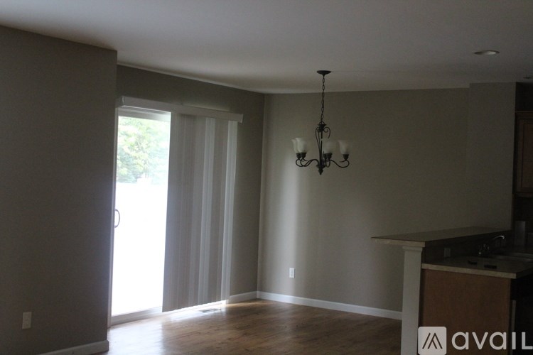 A room with a chandelier and a window with curtains.