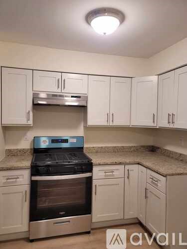 A kitchen with white cabinets and a stainless steel oven.