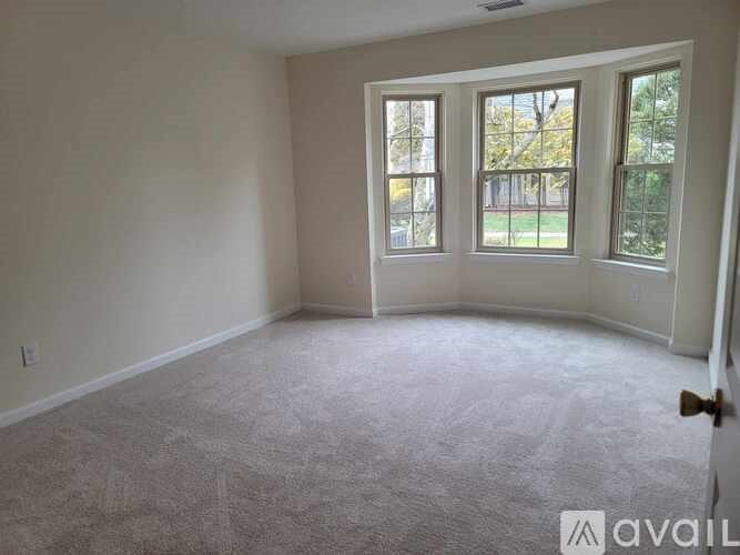 A room with a carpeted floor and a door on the right side.