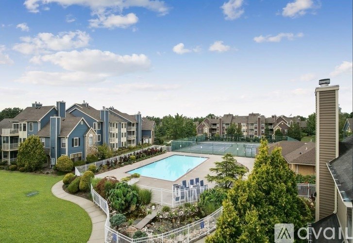 A large apartment complex with a pool and a tennis court.