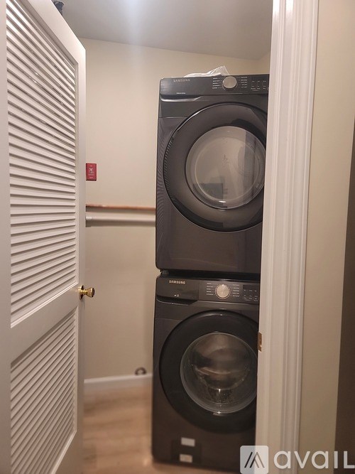A black washing machine is in a small room.