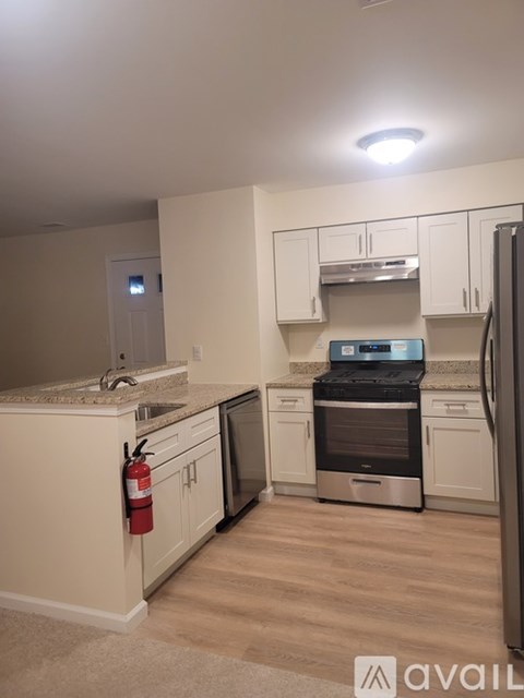 A kitchen with a stove top oven and a refrigerator.