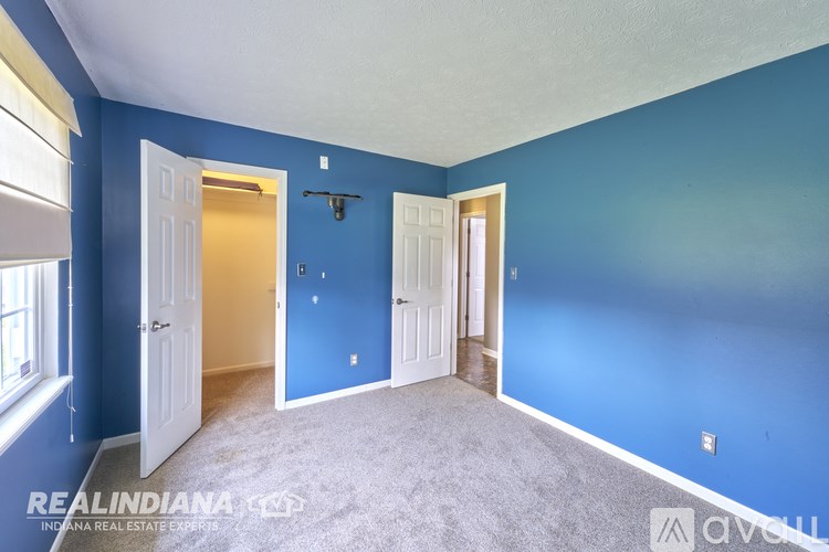 A room with blue walls and carpeted floor.