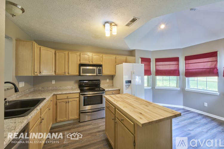 A kitchen with wooden cabinets and a wooden island.