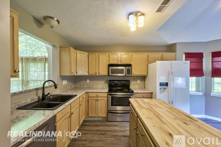 A kitchen with wooden cabinets and a white refrigerator.