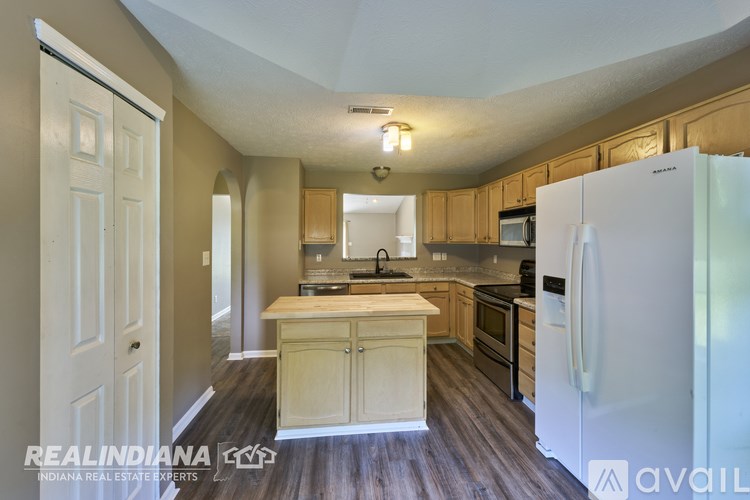 A kitchen with wooden cabinets and a white refrigerator.