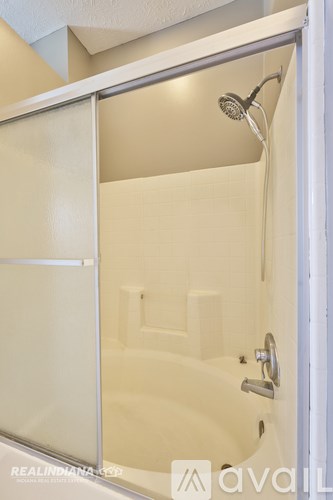 A white bathroom with a shower and a towel bar.