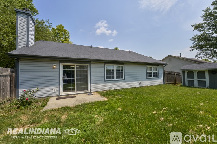 A house with a grey roof and a chimney is for sale.