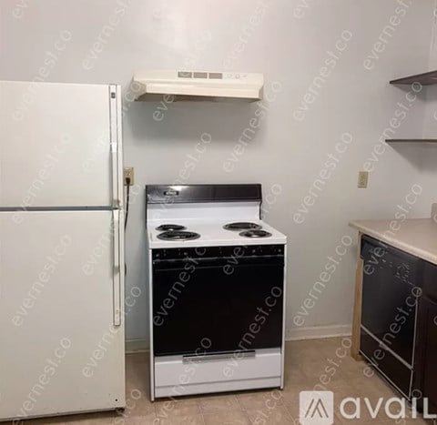 A white refrigerator is next to a white stove in a kitchen.