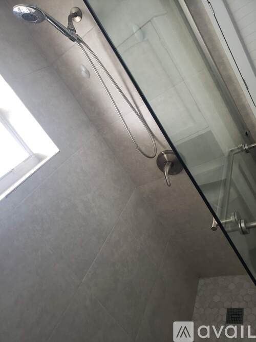 A shower head is mounted on a glass wall.