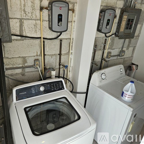 A wall-mounted electricity meter is installed next to a washing machine.