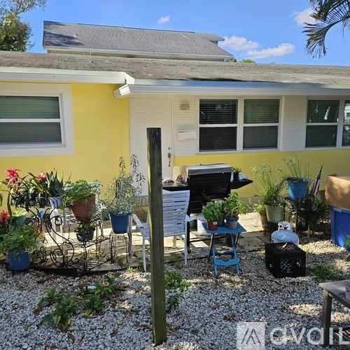 A yellow house with a patio and a grill.