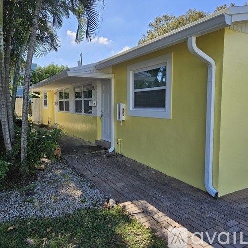 A yellow house with a white door and windows.