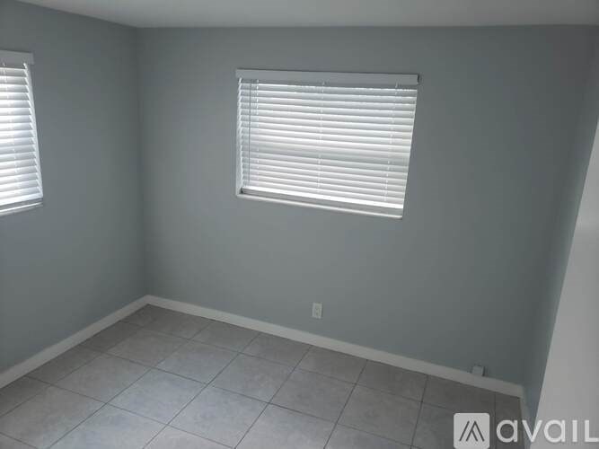A room with a window and tiled floor.