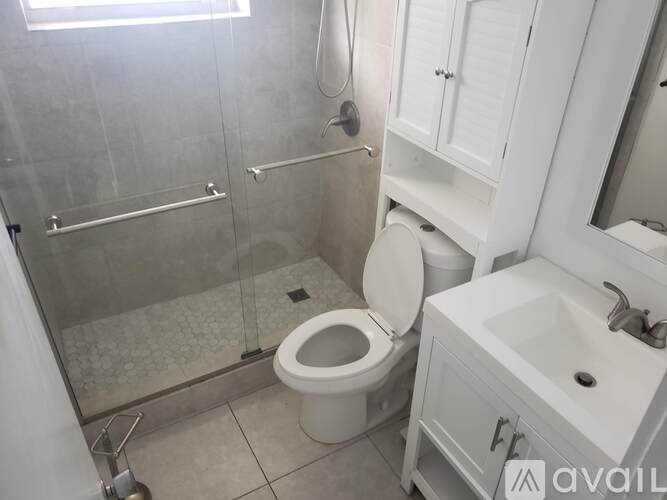 A white toilet sits in a bathroom next to a sink.