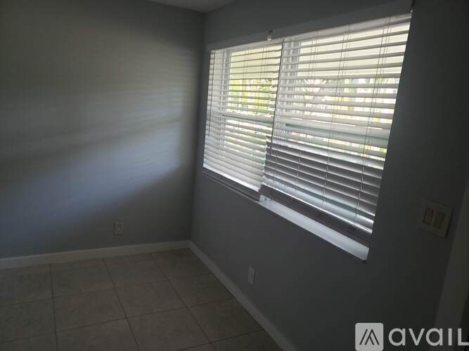 A room with a window covered in blinds.