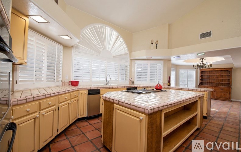 A kitchen with wooden cabinets and a tiled countertop.