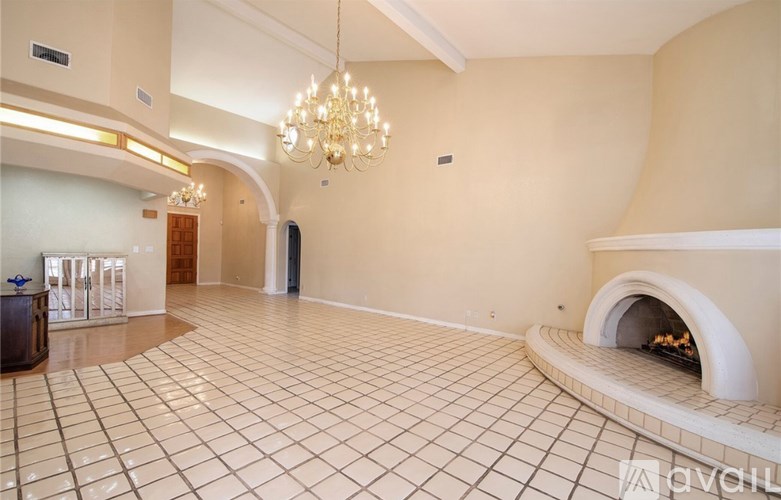 A large room with a fireplace and a chandelier.