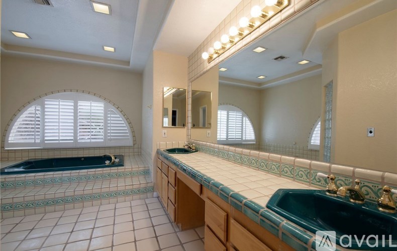 A bathroom with a large mirror and a green sink.