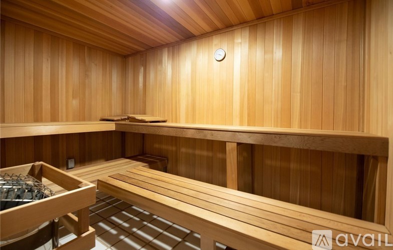 A wooden sauna room with benches and a heater.