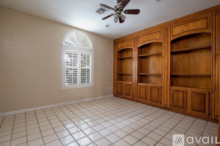 A room with wooden cabinets and a ceiling fan.