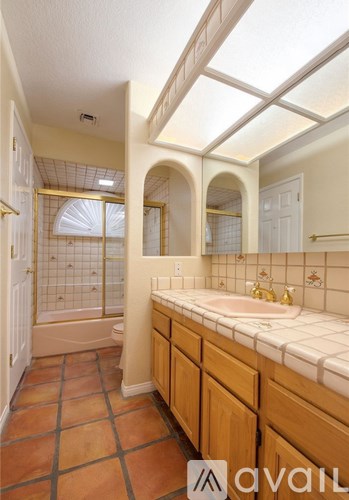 A bathroom with a tiled floor and a skylight.