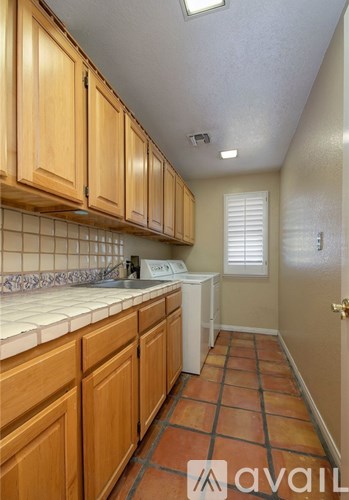 A kitchen with wooden cabinets and a tiled floor.