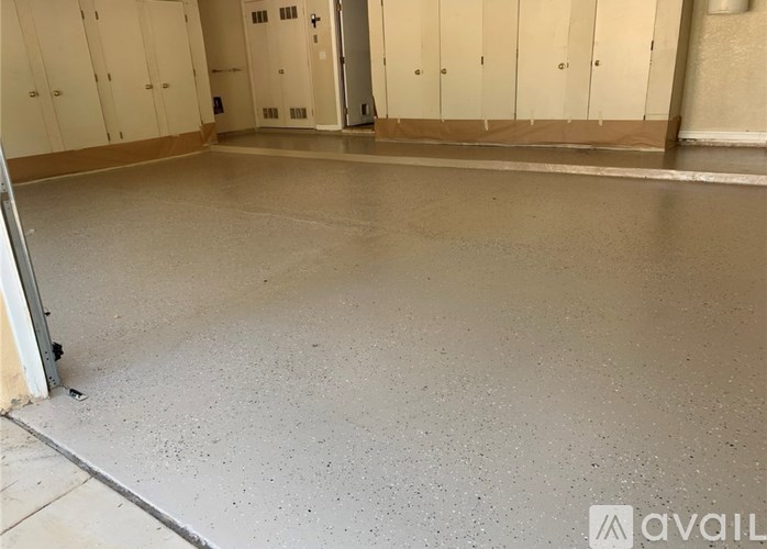 A large, empty room with a concrete floor and white walls.