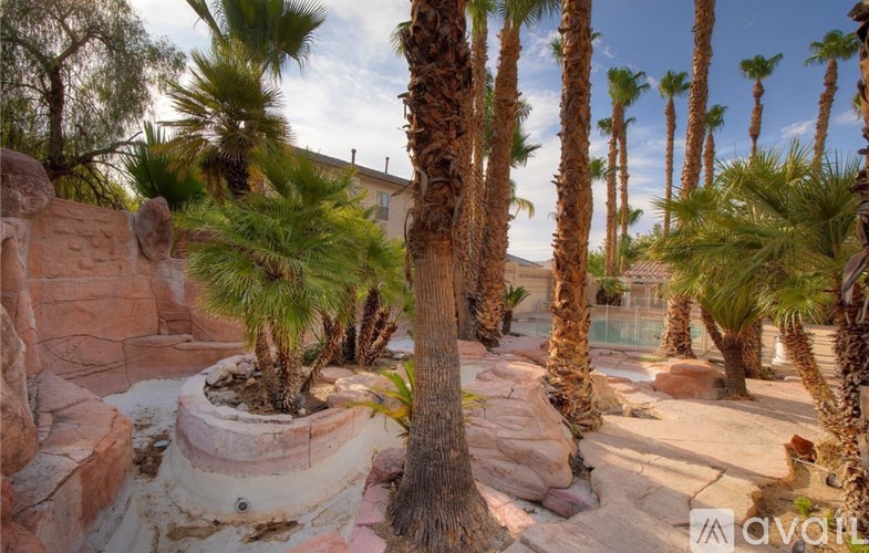 A desert landscape with palm trees and rock formations.