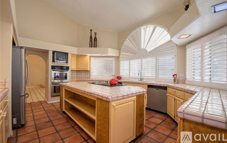 A kitchen with a refrigerator, microwave, oven, and a dishwasher.