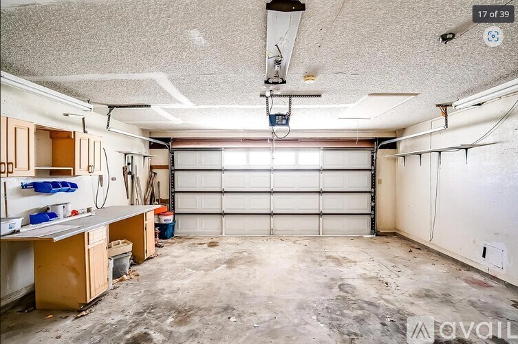 A spacious garage with a white ceiling and a large white door is available for rent.