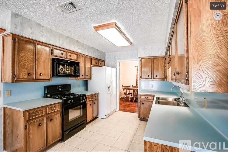 A kitchen with wooden cabinets and a black stove top oven.
