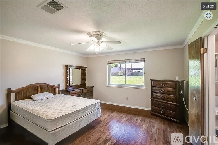 A bedroom with a bed, dresser, and mirror.