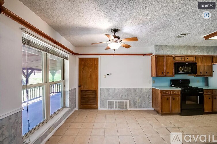 A kitchen with a black stove top oven and wooden cabinets.