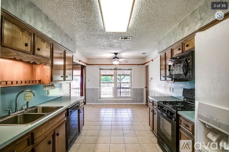 A kitchen with wooden cabinets and a tiled floor.