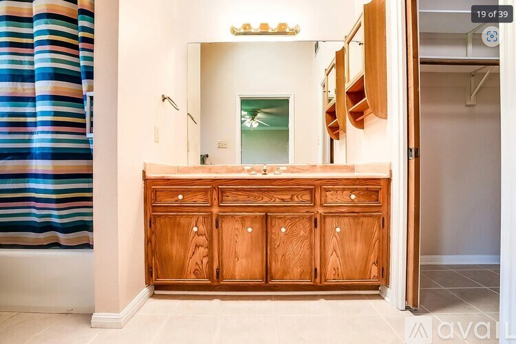 A wooden cabinet with a mirror above it in a room.