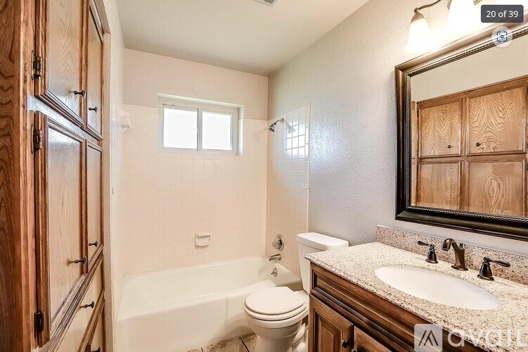 A bathroom with a white tub, sink, and toilet.