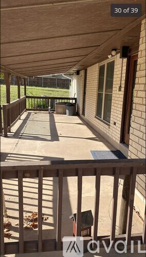 A balcony with a railing and a view of a yard.