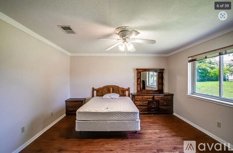 A bedroom with a bed, dresser, and mirror.