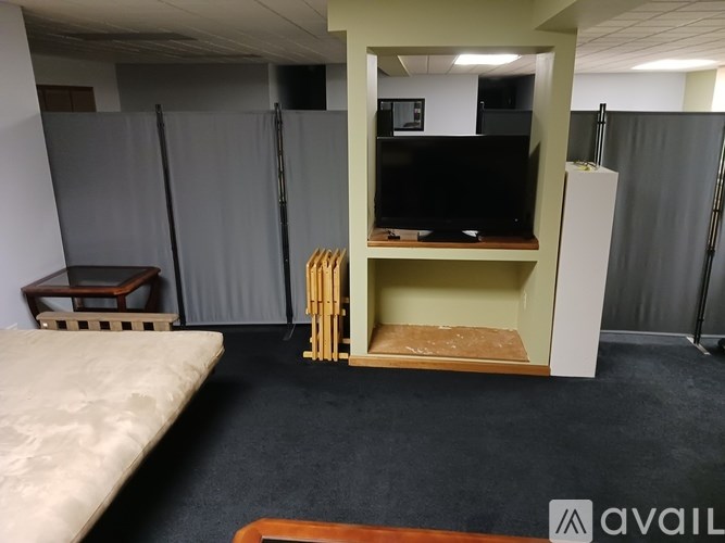 A room with a bed, a desk, and a television.
