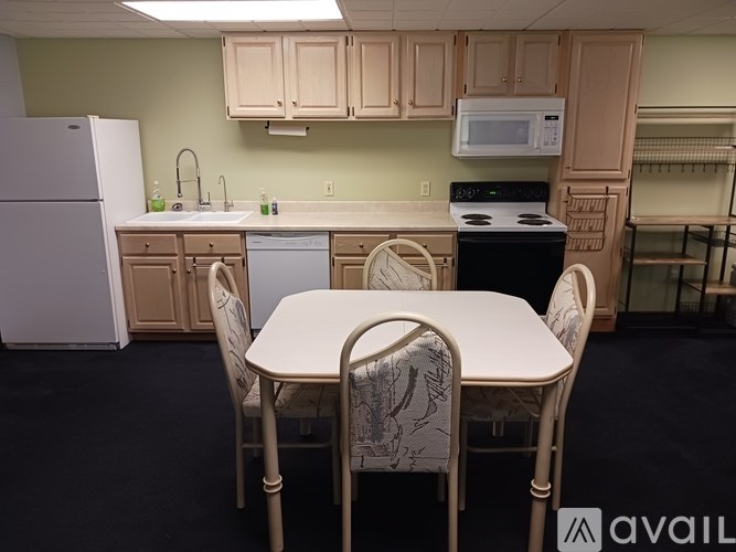 A kitchen with a table and chairs in the foreground.
