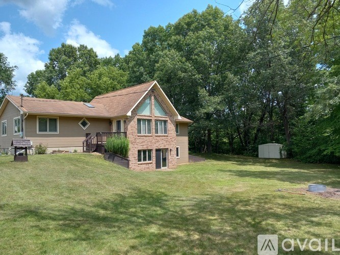 A house with a brown roof and a green lawn in front.
