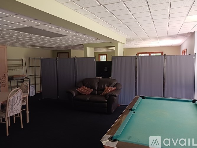 A room with a pool table and a couch.