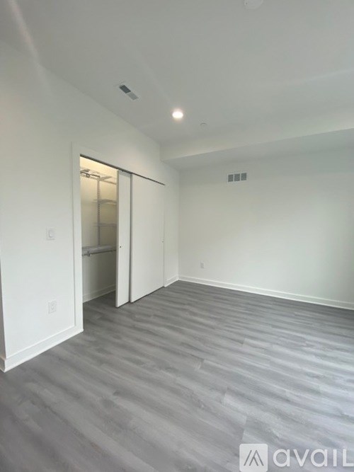 A room with a grey floor and white walls is available for rent.