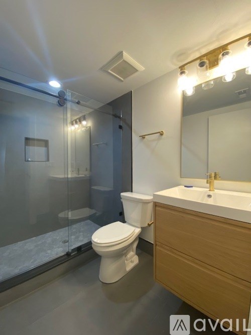 A bathroom with a toilet, sink, and mirror.