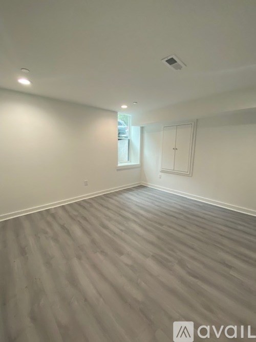 A room with wooden flooring and white walls.